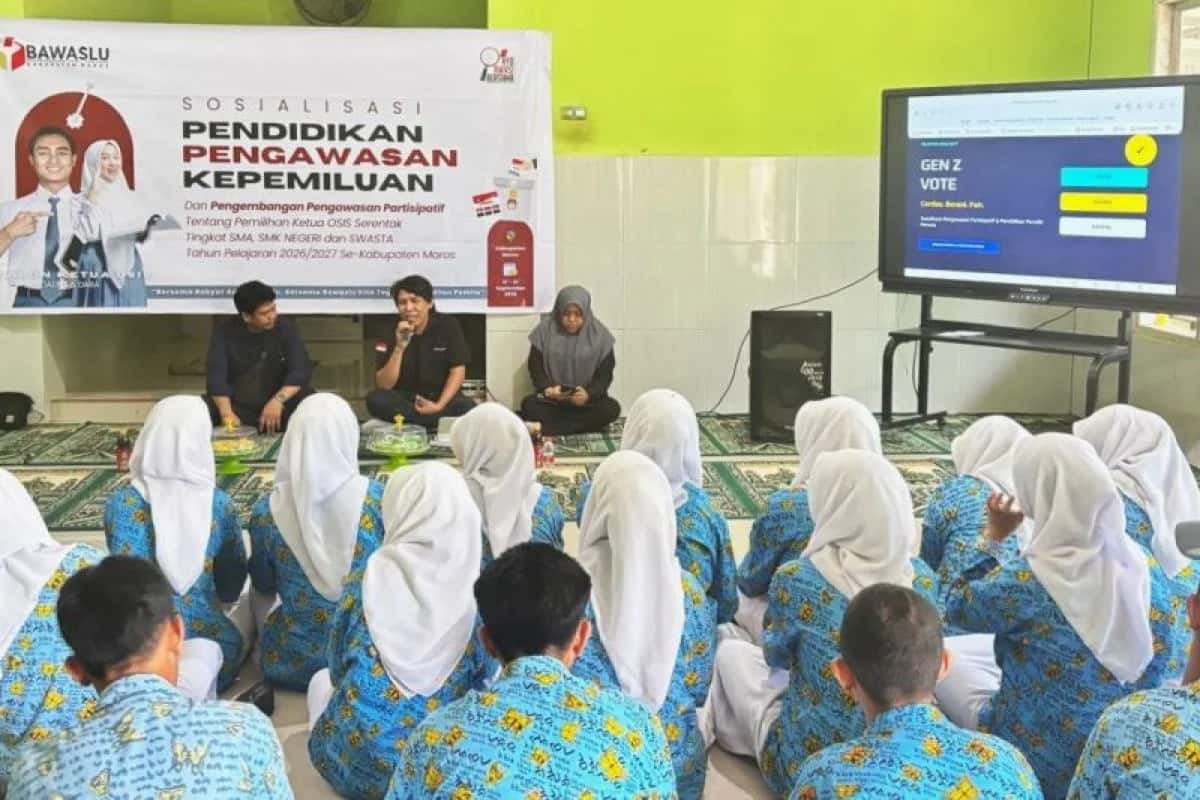 Pelajar berseragam duduk menghadap narasumber dan layar sosialisasi pengawasan kepemiluan Bawaslu Maros