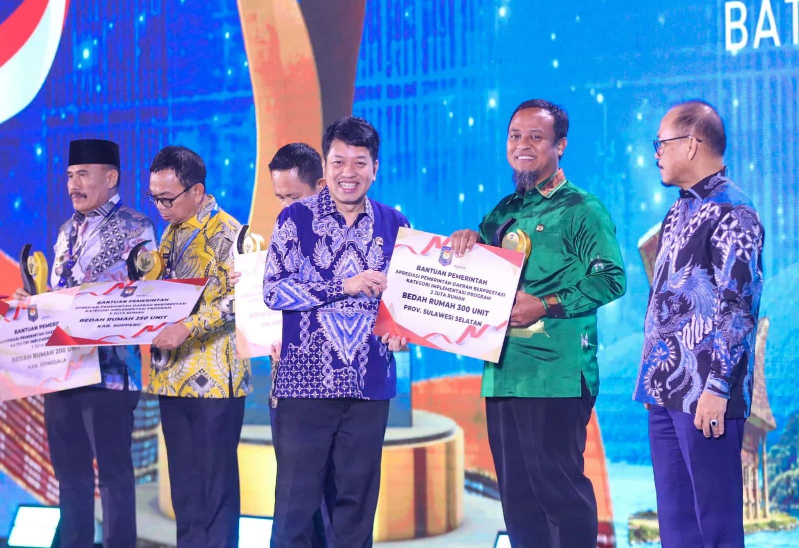 Gubernur Sulsel bersama pejabat lain memegang papan bantuan bedah rumah 300 unit
