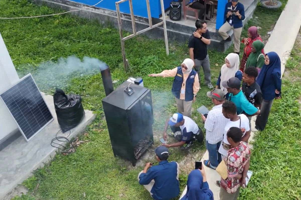 Peserta mengelilingi alat pengering berwarna hitam dengan panel surya saat tim Unhas menjelaskan pengoperasiannya