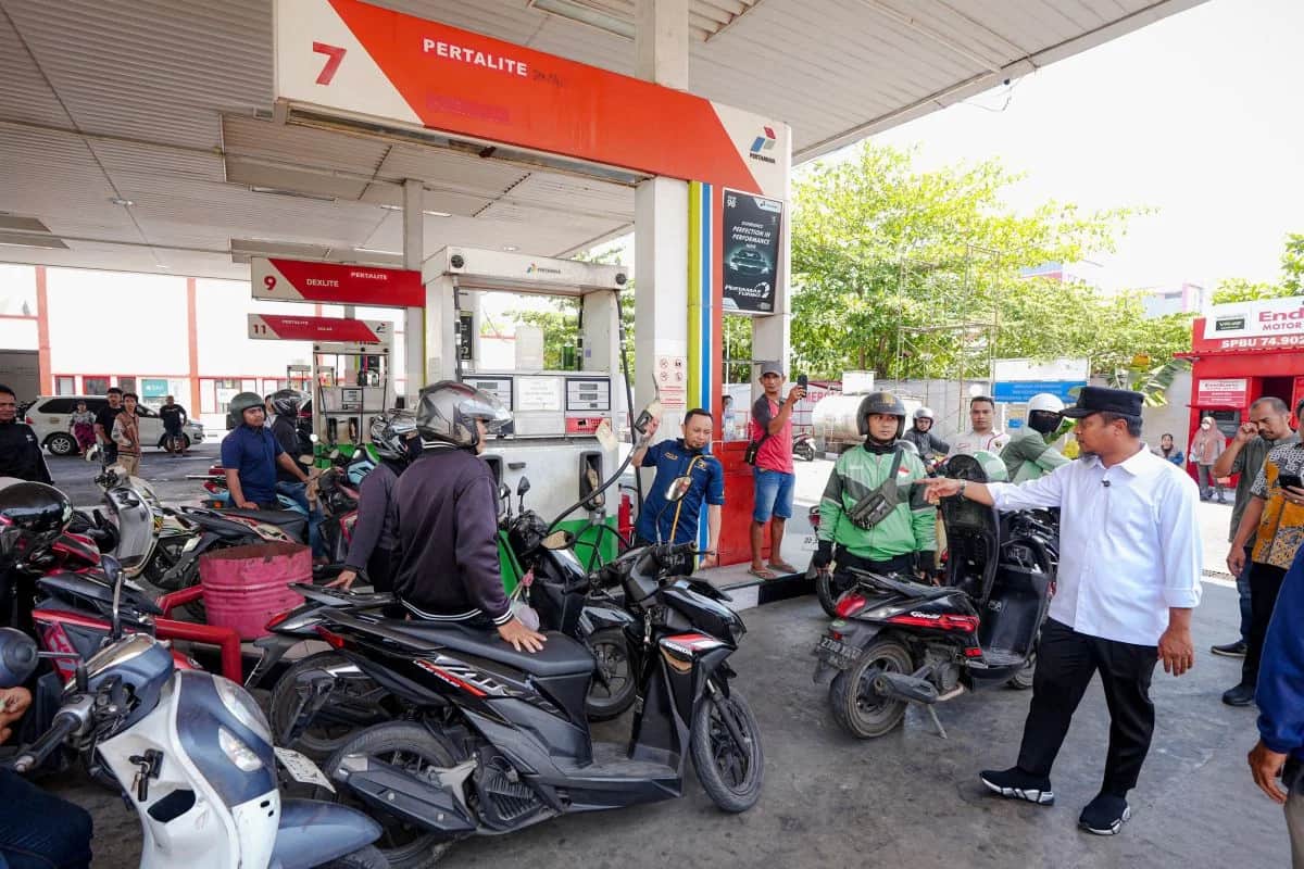 Andi Sudirman menunjuk area pengisian Pertalite di antara pengendara sepeda motor dan petugas SPBU