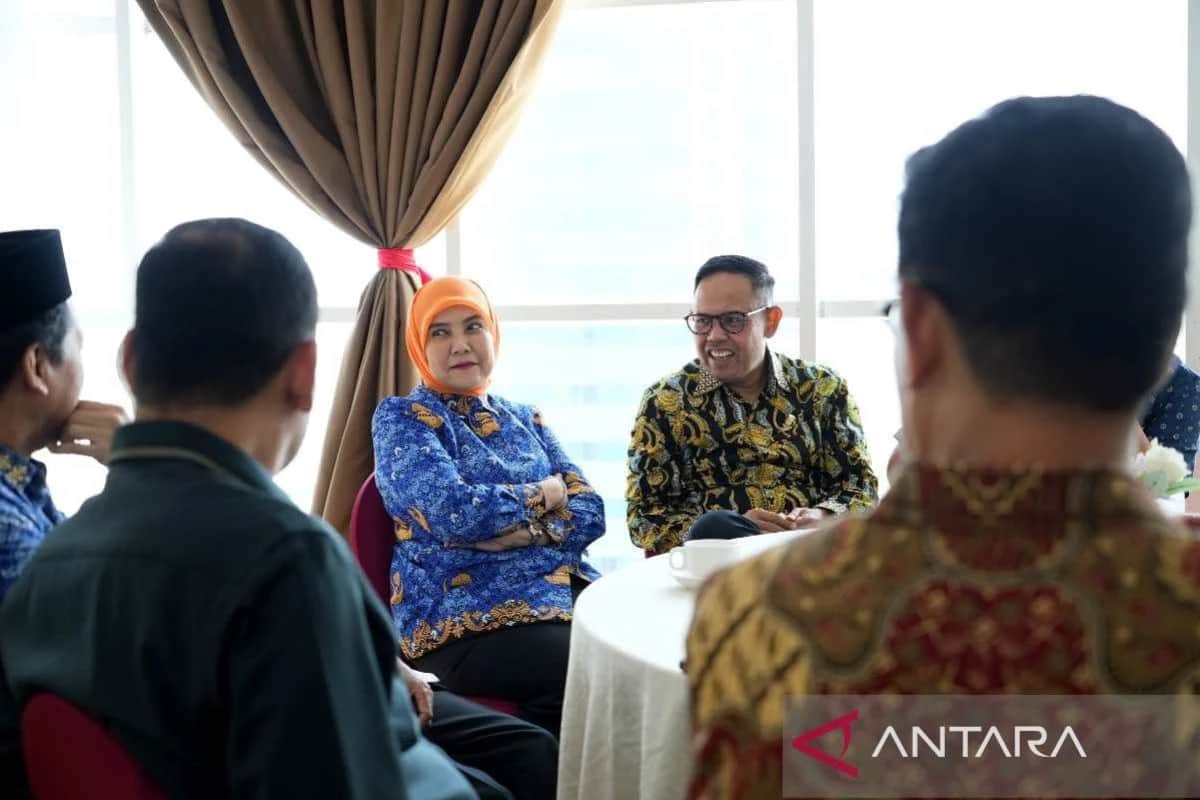 Aliyah Mustika Ilham duduk bersama peserta pertemuan di dalam ruangan