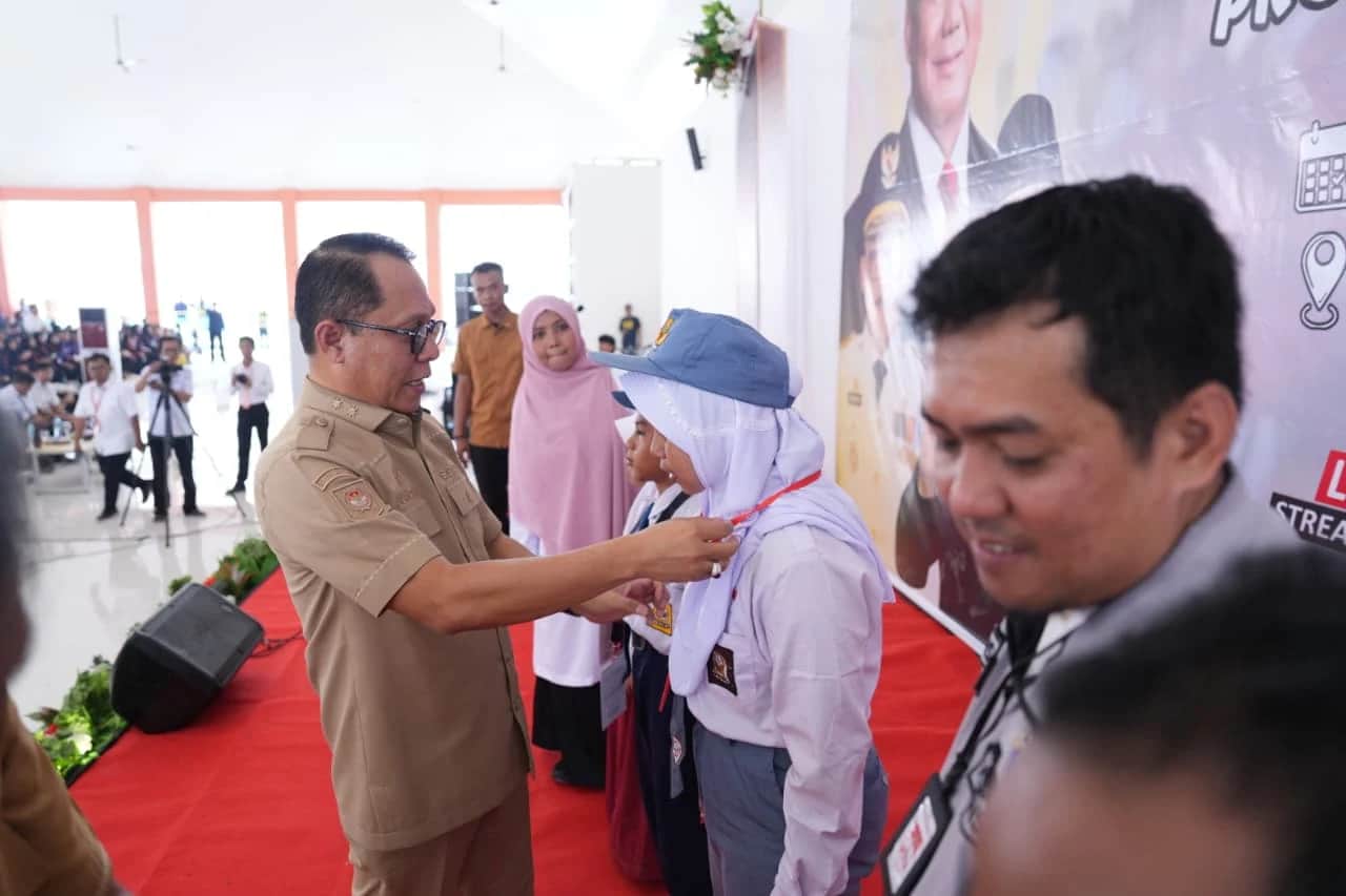Junda Maulana memasangkan tanda peserta kepada siswi saat pembukaan MPLS di Mamuju
