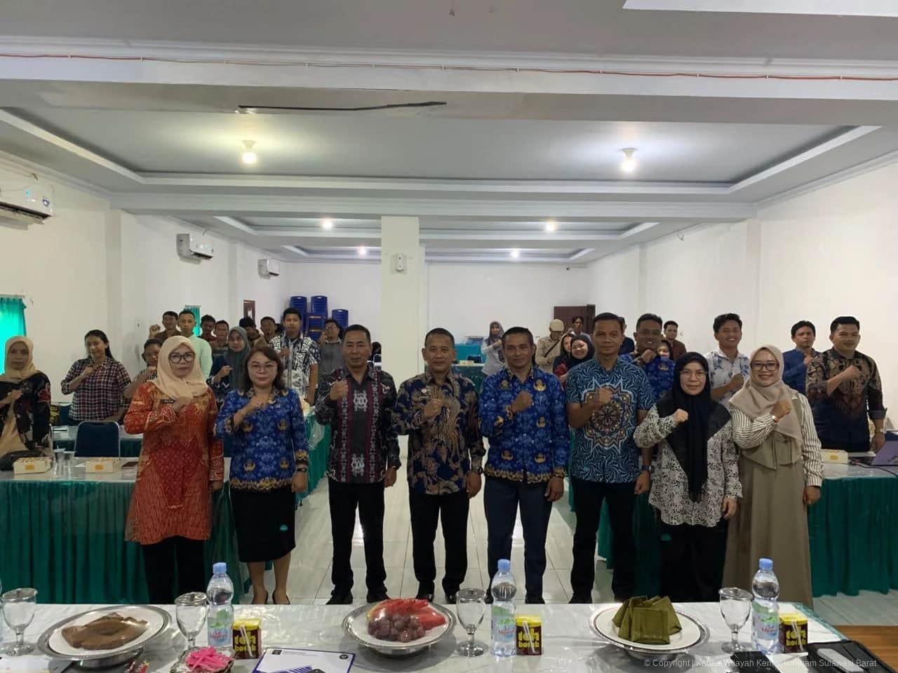 Peserta dan jajaran Kemenkum Sulbar berfoto bersama di ruang kegiatan dengan meja berlapis kain hijau