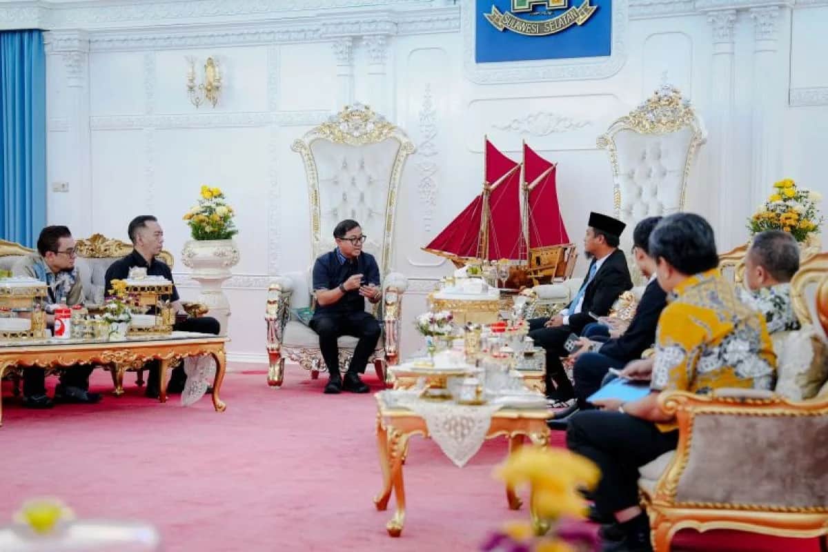 Gubernur dan rombongan Pertamina duduk berhadapan di ruang pertemuan dengan miniatur perahu