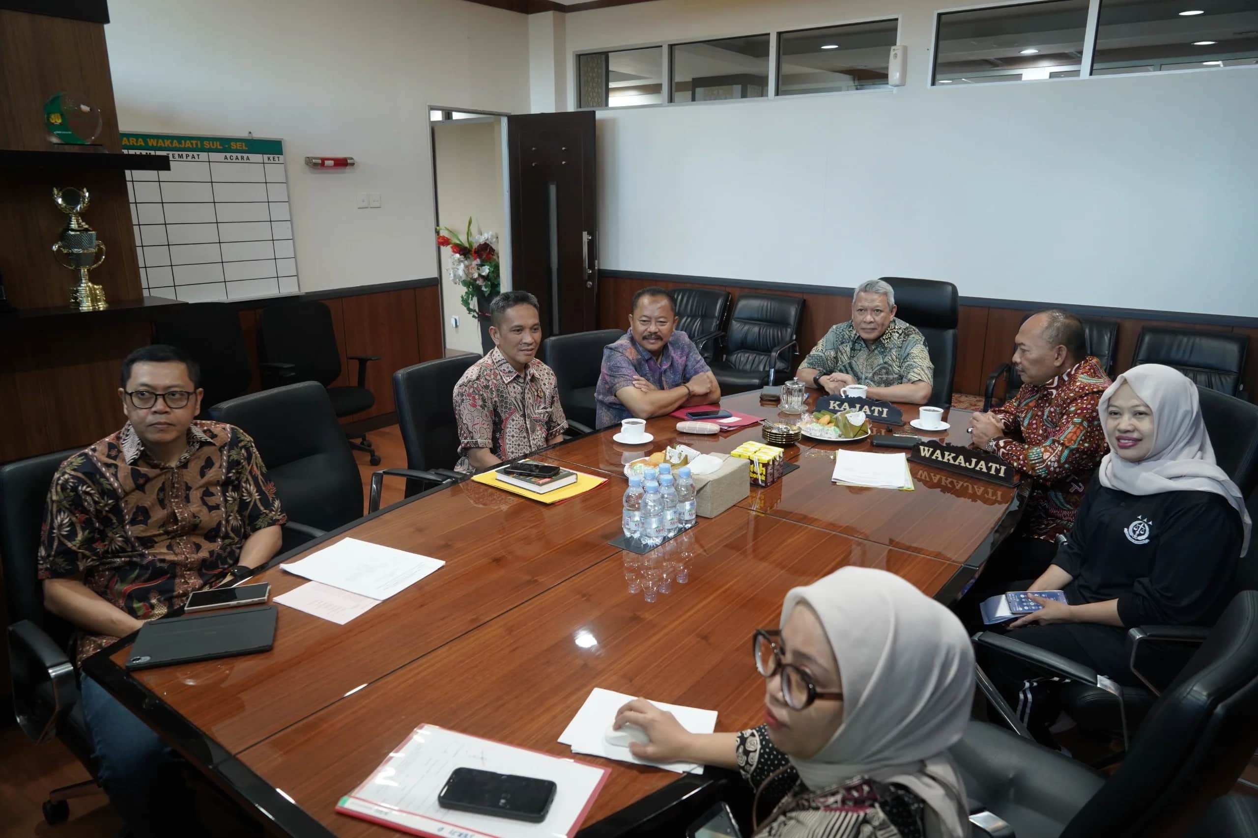 Peserta rapat duduk mengelilingi meja di ruang Kejaksaan Tinggi Sulawesi Selatan