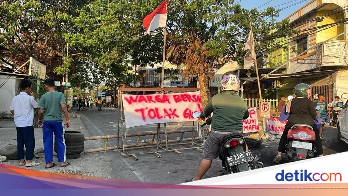 Warga dan pengendara berada di depan barikade penutup jalan di Borong Raya Makassar