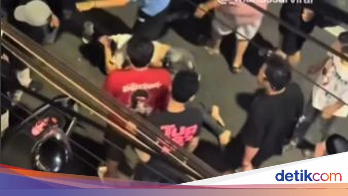 Sejumlah orang mengelilingi seorang pemuda yang terjatuh di Jalan Penghibur Makassar pada malam hari