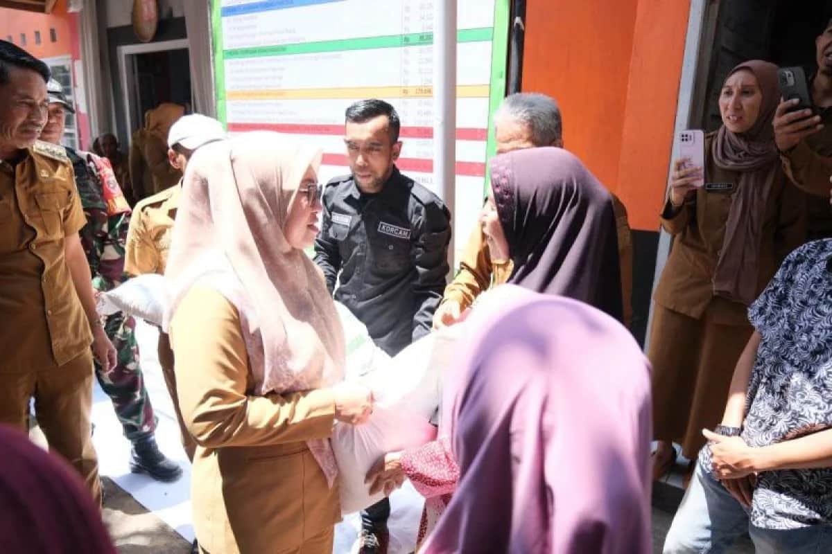 Sitti Husniah Talenrang menyerahkan karung beras kepada warga di Parigi