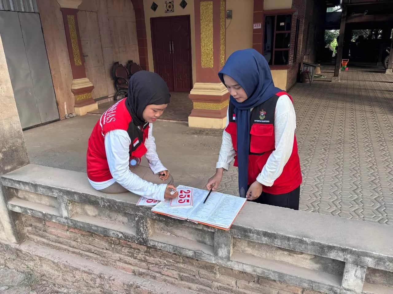 Mahasiswa KKN Unhas memasang nomor alamat rumah di Desa Ajubissue Sidrap